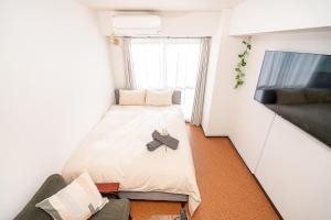 a small room with a bed and a flat screen tv at 新宿歌舞伎町東新宿站3分钟，徒步伊势丹4分钟免费Wi-Fi！ in Tokyo