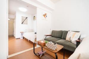 a living room with a couch and a bed at 新宿歌舞伎町東新宿站3分钟，徒步伊势丹4分钟免费Wi-Fi！ in Tokyo