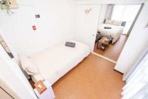 a small room with two beds and a mirror at 新宿歌舞伎町東新宿站3分钟，徒步伊势丹4分钟免费Wi-Fi！ in Tokyo