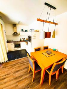 eine Küche und ein Esszimmer mit einem Holztisch und Stühlen in der Unterkunft Ferienwohnung für 4 Personen ca 55 m in Rauris, Salzburger Land Rauristal in Rauris