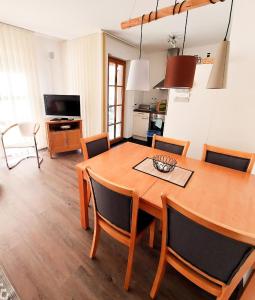 eine Küche und ein Esszimmer mit einem Holztisch und Stühlen in der Unterkunft Ferienwohnung für 4 Personen ca 55 m in Rauris, Salzburger Land Rauristal in Rauris
