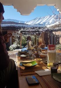 ein Tisch mit Essen drauf mit Bergen im Hintergrund in der Unterkunft Alliance Berbère - Vallée d'Aït Bouguemez in Timit