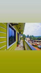ein gelbes Gebäude mit einem Fenster auf dem Balkon in der Unterkunft The Baga beach 24in in Calangute