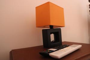 une lampe avec une boîte au-dessus d'une télécommande dans l'établissement Casa do Avô Gil, à Seixo