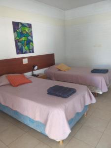 a room with three beds in a room at hotel el retorno in Catriel