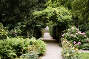 a garden with a path with flowers and plants at Parkhotel Laurin in Bolzano