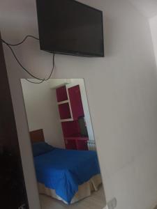 a bedroom with a bed and a flat screen tv on a wall at hotel el retorno in Catriel