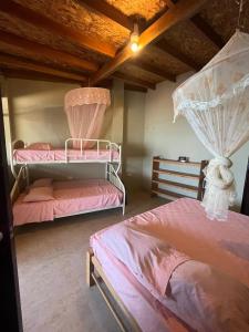 two beds in a room with pink sheets at DEPARTAMENTO FRENTE AL MAR NUEVO LOBITOS DEBAJO DEL ALBERGUe in Barrio Bellavista
