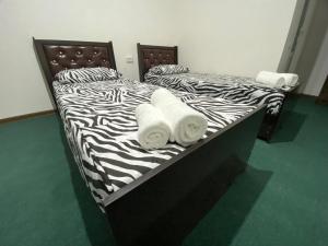 2 camas en una habitación con estampado de cebra en Family Hotel, en Samarkand