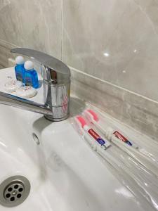 un fregadero con cepillos de dientes y pasta de dientes en Family Hotel, en Samarkand