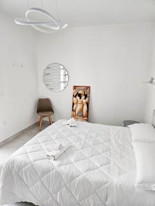 a white bedroom with a white bed and a chair at Il Nido in Marina di Montenero