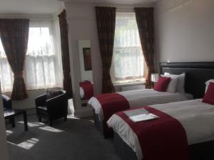 una habitación de hotel con 2 camas y una silla en Croham Park B&B - Free Parking & Wi-Fi, en Croydon