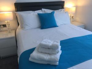 a bed with white towels on top of it at Croham Park B&B - Free Parking & Wi-Fi in Croydon