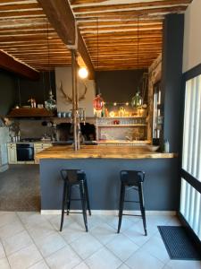 a kitchen with two bar stools at a counter at Maison spacieuse & chaleureuse au cœur du village in Cases-de-Pène