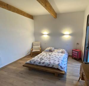 a bedroom with a bed and a chair in it at Maison spacieuse & chaleureuse au cœur du village in Cases-de-Pène