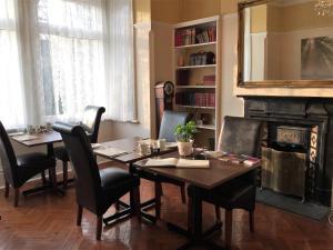 a dining room with a table and chairs and a fireplace at Croham Park B&B - Free Parking & Wi-Fi in Croydon