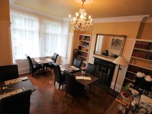 uma sala de estar com uma mesa e cadeiras e uma lareira em Croham Park B&B - Free Parking & Wi-Fi em Croydon