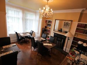 - un salon avec une table, des chaises et une cheminée dans l'établissement Croham Park B&B - Free Parking & Wi-Fi, à Croydon