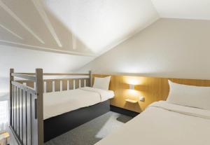 Habitación pequeña con 2 camas y paredes blancas. en B&B HOTEL CALAIS Coquelles Tunnel sous La Manche en Coquelles