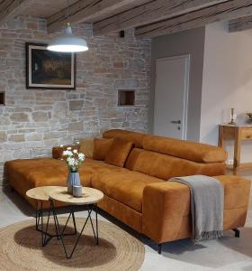 a brown leather couch in a living room with a table at VILA ŠKARLANIJA, Umag in Umag