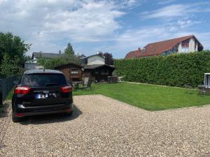 a car parked in a gravel parking lot with a yard at Haus Ostwind - Wohnung 2 in Dahme