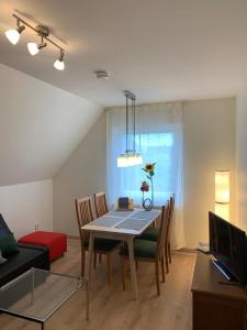 a living room with a table and chairs and a couch at Haus Ostwind - Wohnung 2 in Dahme