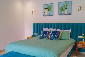 een bed met een blauw hoofdeinde in een slaapkamer bij Luxury Marina Appartement Agadir in Agadir