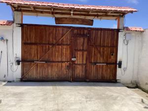 une grande porte de garage en bois sur une maison dans l'établissement Villa Comando Privacidad Cerca al Mar, à Briseño