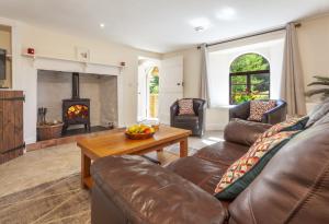 a living room with a couch and a fireplace at Barn Owl Cottage Wheddon Cross in Wheddon Cross