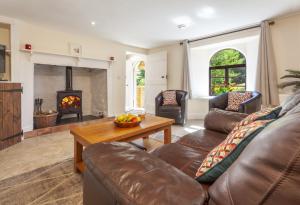 a living room with a couch and a fireplace at Barn Owl Cottage Wheddon Cross in Wheddon Cross
