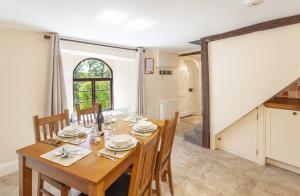 a dining room with a wooden table and chairs at Barn Owl Cottage Wheddon Cross in Wheddon Cross