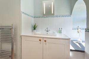 a white bathroom with a sink and a shower at Barn Owl Cottage Wheddon Cross in Wheddon Cross +24 photos