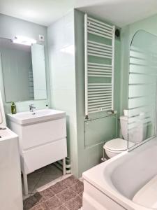 uma casa de banho com uma banheira, um lavatório e um WC. em L'Erlon Cosy : hyper centre - proximité gare em Reims