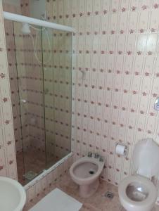 a bathroom with a toilet and a glass shower at Conora hotel in Itatiaia
