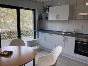 a kitchen with white cabinets and a table and a window at Ferienwohnung Friedsam in Niederzissen