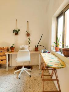 einen Schreibtisch und einen Stuhl in einem Zimmer mit Pflanzen in der Unterkunft Cute Townhouse in Maltese Village Close To St Peters Pool in Żejtun