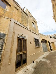 ein altes Gebäude mit einem Seitenfenster in der Unterkunft Cute Townhouse in Maltese Village Close To St Peters Pool in Żejtun