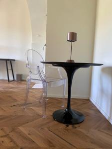 una mesa negra y 2 sillas en un suelo de madera en B&B San Nicola, en Porchia
