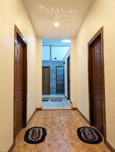 a hallway with two doors and two rugs on the floor at STAY Hostel & Motorbike Rental - Thakhek in Thakhek
