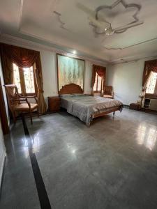 a bedroom with a large bed and two chairs at STONEROCK CASTLE in Hyderabad