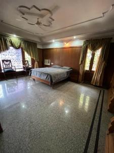 a bedroom with a bed in a room with windows at STONEROCK CASTLE in Hyderabad