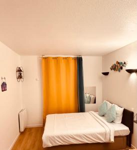 クルブヴォアにあるRyan Homes Studio - in Aparthotel, La Défenseのベッドルーム(オレンジ色のカーテン、ベッド付)