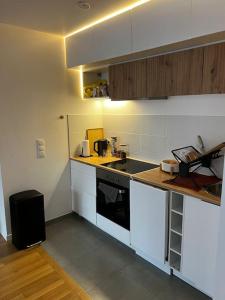 uma cozinha com armários brancos e uma bancada em Moderne Cosy Appartement em Clichy