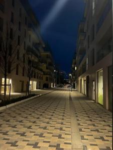 uma rua da cidade vazia à noite com edifícios em Moderne Cosy Appartement em Clichy