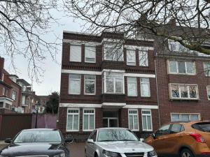due auto parcheggiate di fronte a un edificio di mattoni di Duc Anh Ferienwohnung a Emden
