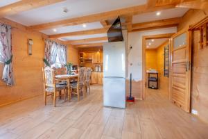 Una cocina con refrigerador y una mesa con sillas. en Domek za Wierchem, en Małe Ciche