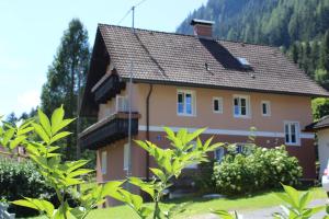 una casa con una montaña en el fondo en Haus Feldseeblick en Feld am See