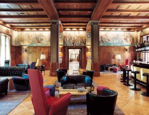 a lobby with couches and chairs and a bar at Parkhotel Laurin in Bolzano