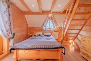 Un dormitorio con una cama en una casa de madera. en Domek za Wierchem, en Małe Ciche