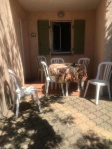 une table et des chaises assises sur une terrasse avec une table et des chaises dans l'établissement joli 2 pieces vue mer , piscine proche ste Maxime résidence BELLEVUE, à Roquebrune-sur Argens 8 autres photos
